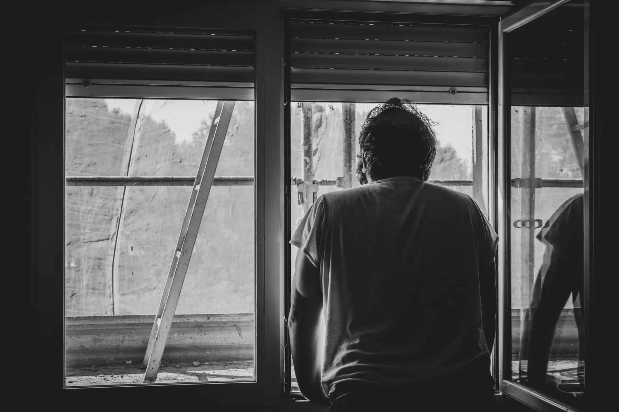 Man looking out window