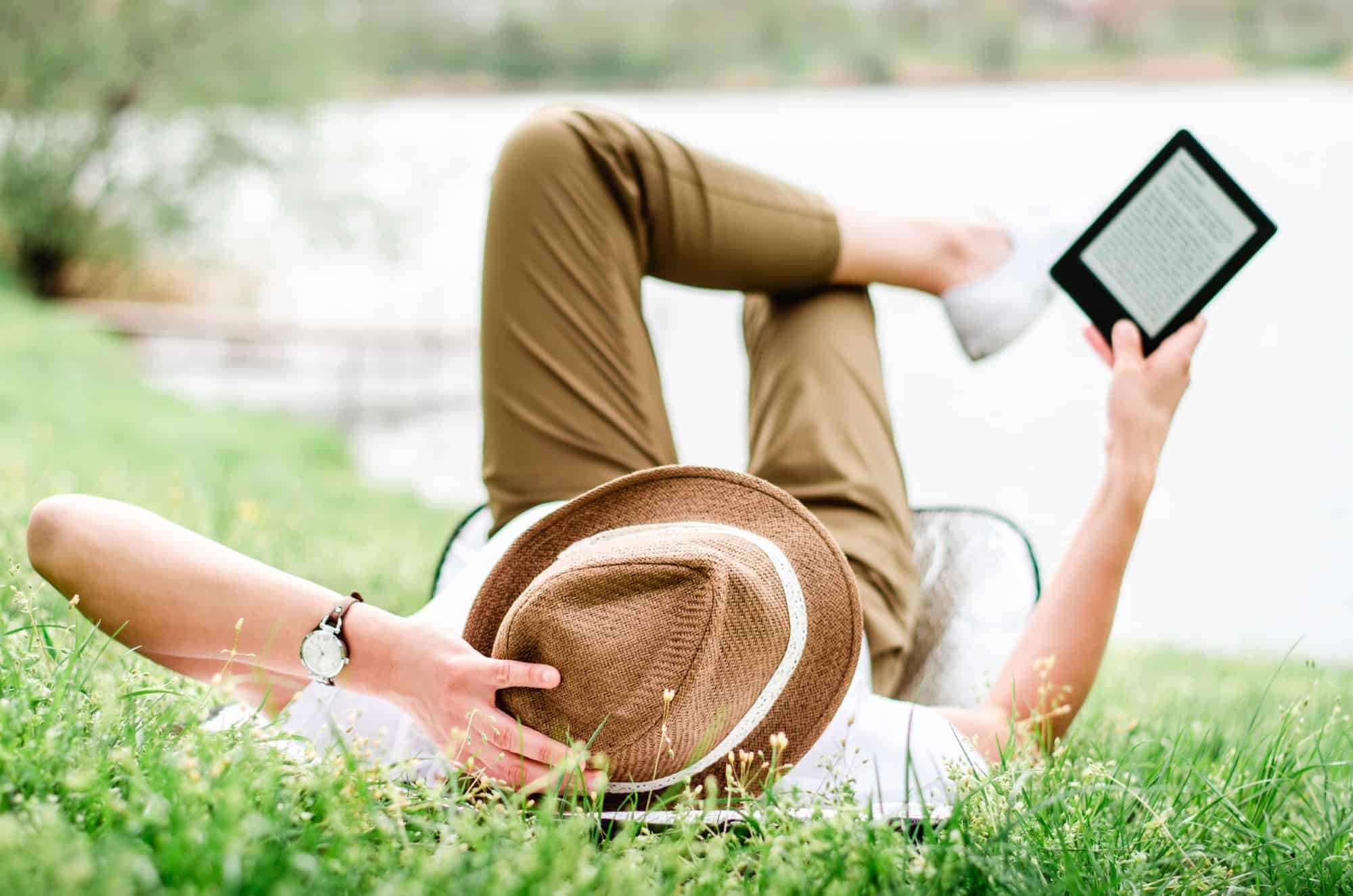 Woman in hat reading Kindle